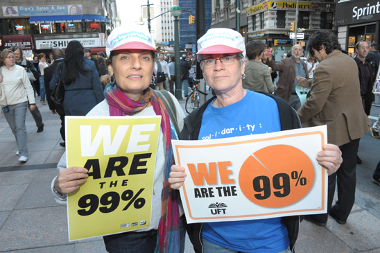 UFT members Donna Fiscina of PS 15 in Manhattan and Marci Pepper of PS 94 in Manhattan get behind the “We are the 99%” signs. (Miller Photography)