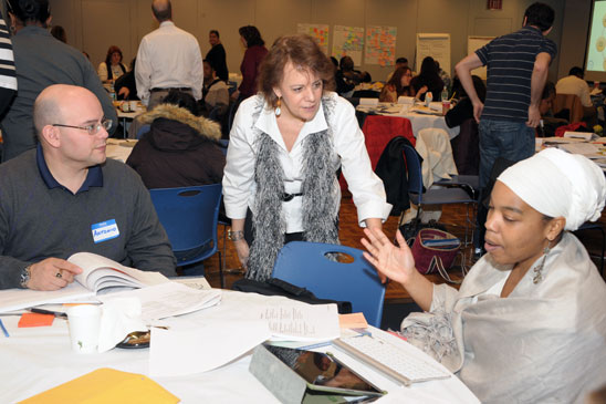 Fortino (standing) discusses Danielson with Andolyn Brown and Principal Antonio 