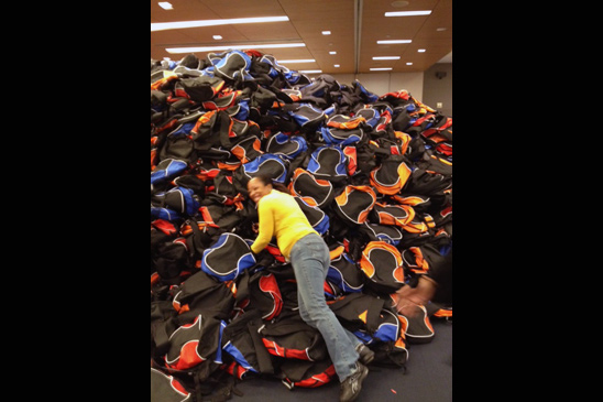Jessica Timo, a UFT procurement facilitator/OPEIU 153 shop steward, jumps into the mountain of donated backpacks for displaced students. Timo was instrumental in the UFT's backpack project, working 24/7 and weekends supervising staff during the backpack-stuffing operation and preparing for the shipment of the backpacks to the schools. Jessica Timo, a UFT procurement facilitator/OPEIU 153 shop steward, jumps into the mountain of donated backpacks for displaced students. Timo was instrumental in the UFT's backpack project, working 24/7 and weekends supervising staff during the backpack-stuffing operation and preparing for the shipment of the backpacks to the schools.