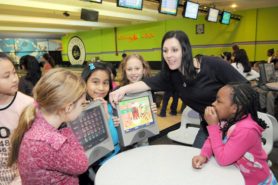 Third-grade teacher Bonnie Pitera and students check out the scoring terminal. (Jonathan Fickies)