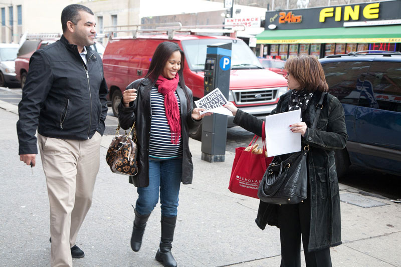 Alexandra Itskovich, who teaches English as a second language at IS 52, Manhattan, gets the union’s message to a couple near an Inwood transit hub. Alexandra Itskovich, who teaches English as a second language at IS 52, Manhattan, gets the union’s message to a couple near an Inwood transit hub. (Pat Arnow)