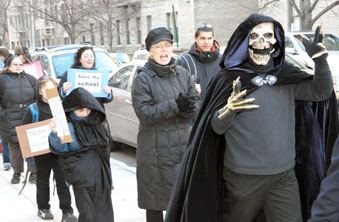 The “Grim Reaper,” parent Linwood Harcum, leads 100 protesting parents in their 