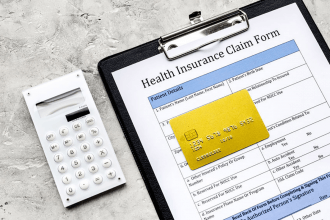 Health Insurance Claim Form on a clipboard with a calculator and credit card
