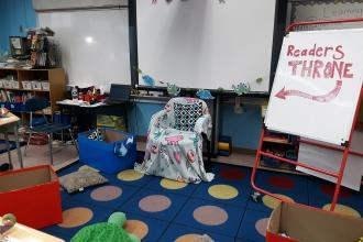 Classroom with comfortable armchair that says "Readers Throne"