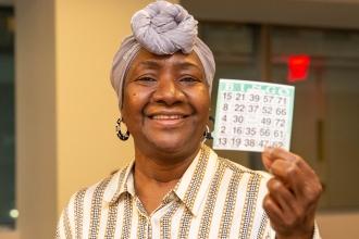 A woman holds up her bingo card