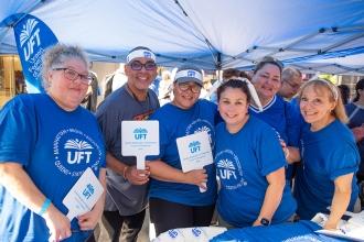 A group of UFT member pose with a giveaway item