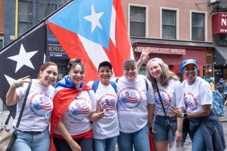 Members pose in front of a Puerto Rico flag 