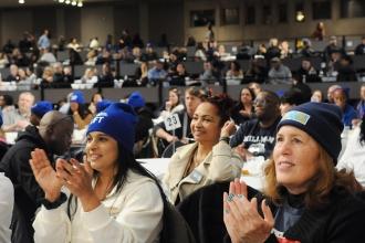 UFT members wearing their union beanies give a round of applause