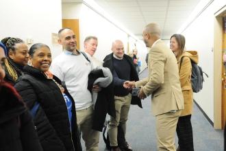 An assemblyman shakes hands with a group of UFT members
