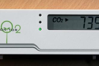 A small device that says CO2 monitor with a digital display that reads 735 ppm