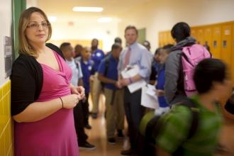 UFT master teacher in pink dress standing in crowded school hallway