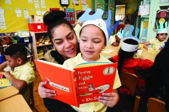 Parent and student in classroom reading Dr. Seuss book