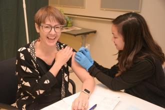 Smiling woman receiving flu shot through UFT health benefits