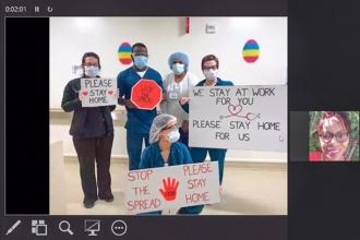 Nurses attend a video call while posing and holding up signs