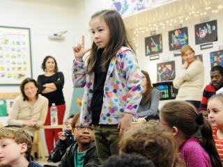 A 2nd-grader introduces herself with her name sign.