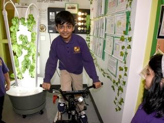 A student uses pedal power to convert human energy into usable energy to power s