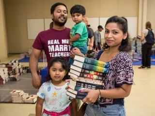 Proma Hassan, a teacher at MS 217 in Queens, stocks up on free books with her fa