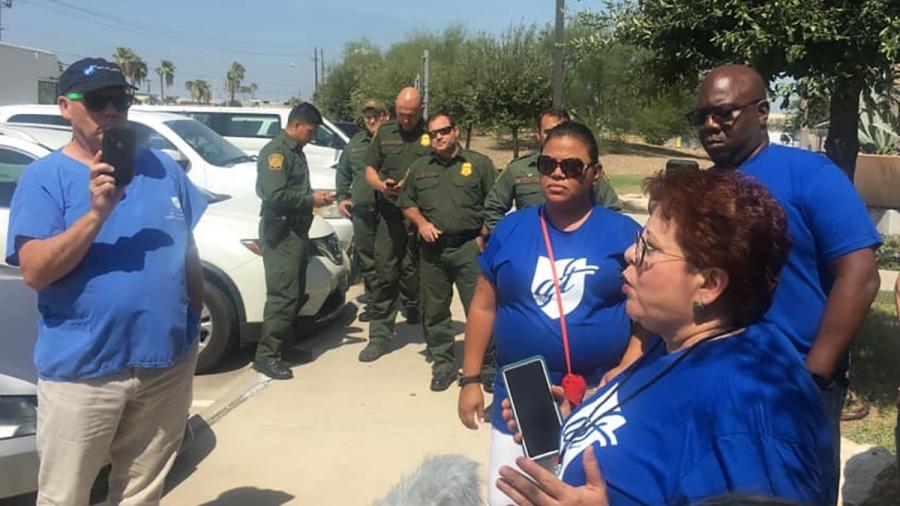 AFT representatives wearing blue AFT shirts with border agents in uniform