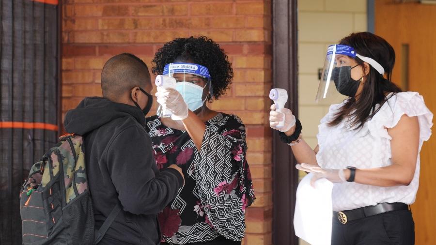 Members of the Building Response Team, including speech teacher Judith Wynter (center), perform temperature checks as students arrive on Sept. 21 for the first day of in-school learning at PS 188 in the Belmont section of the Bronx.