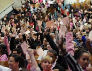 UFT delegates vote with cards in the air.