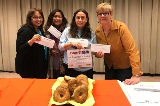 Women holding up ballots and sign "Bagels for Ballots". Bagels are shown in the 