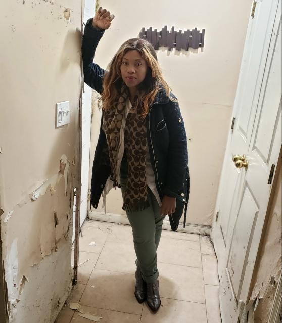 A woman poses in a door way with a serious face