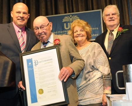 Harold Rothman, holding the proclamation honoring his years of service to the un