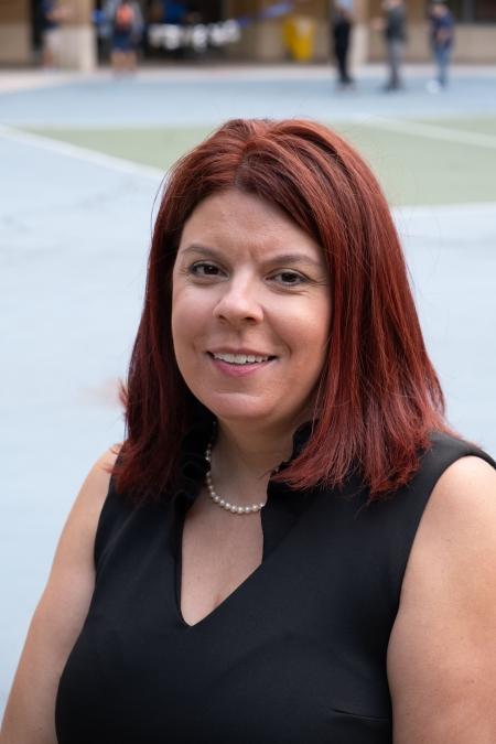A woman poses for a portrait style picture outdoors. 