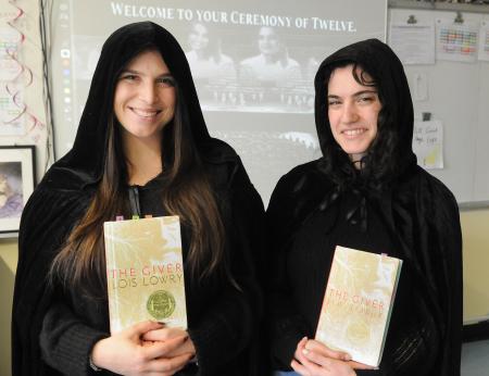  Cristina Cappiello and Arielle Schwartz,  co-teachers at MS 245 in Manhattan take a photo while wearing capes and holding a copy of "The Giver". 
