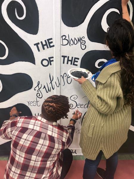 Teachers Sandy Morris Pryce (left) and Erica Bajana work together on a mural of optimism.
