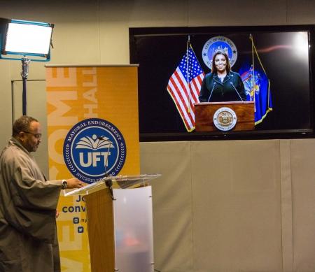 UFT Staff Director Anthony Harmon looks on as State Attorney General Leticia James accepts the John Dewey Award virtually.