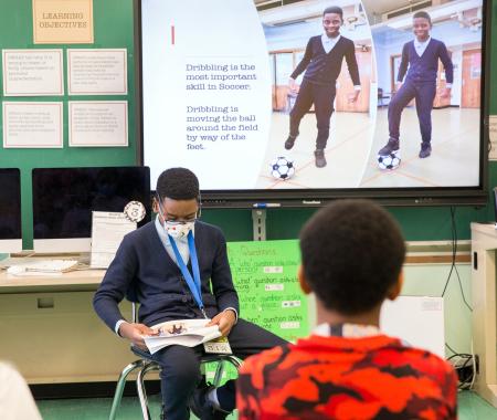 A student reads his original work about soccer.