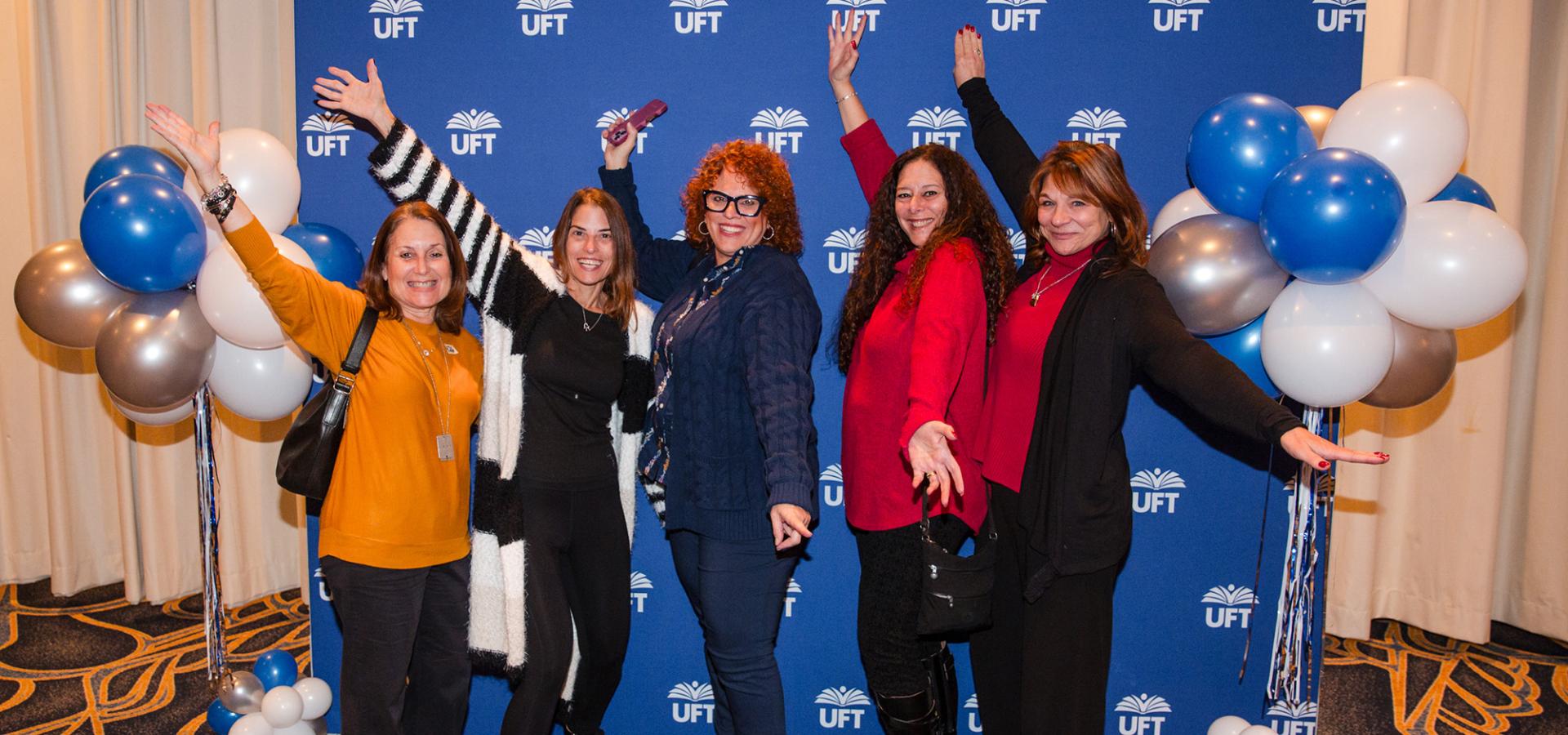 New retirees gather in front of a UFT backdrop for a group photo at the UFT New Retiree Luncheon on Dec. 5, 2024 at the Midtown Hilton