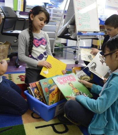Second-graders at Washington Heights Academy check out books the school has received from First Book and the UFT through an Astor Foundation grant.