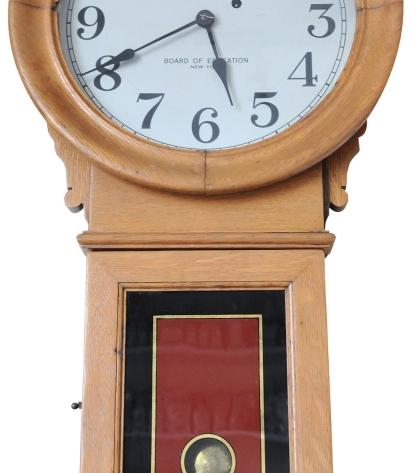 A grandfather clock made of beige wood with red details.