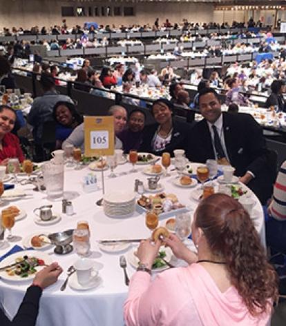 parent activists seated at a table in a crowded hall