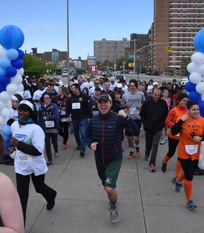 Runners and walkers race past the starting line at MCU Park in Coney Island.