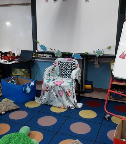 Classroom with comfortable armchair that says "Readers Throne"
