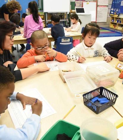 Teacher Christina Tang (left) and learning leader Laura Zelada help kindergartne