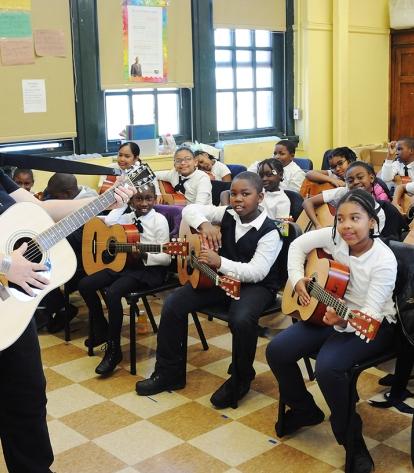 Mahasin Nor-Pomarico directs 3rdgraders on guitars she bought with donations fro