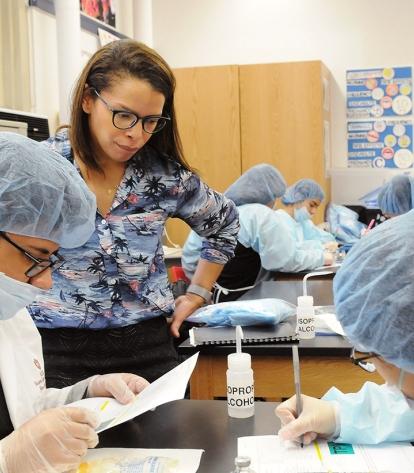 Teacher Leonela Garcia checks as a student team prepares a doctor’s prescription