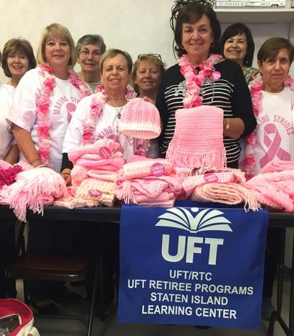 Staten Island knit and crochet class members pose with scarves, hats and headban