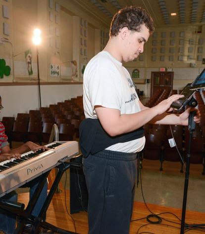 Tobi, 16, plays the keyboard, and Ryan, 18, finds the right note on his iPad. Go
