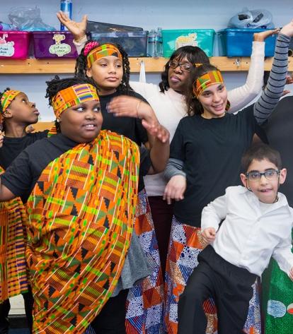 Paraprofessional Roslyn William (background) helps students prepare for their pe