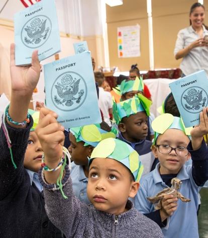 Chapter Leader Deborah Sherman (left) has her students hold up their “passports.