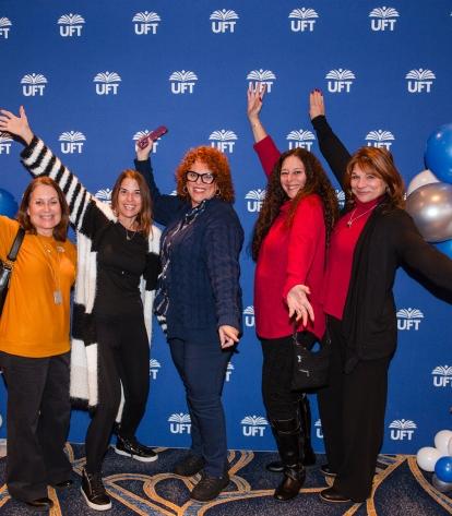 New retirees gather in front of a UFT backdrop for a group photo at the UFT New Retiree Luncheon on Dec. 5, 2024 at the Midtown Hilton