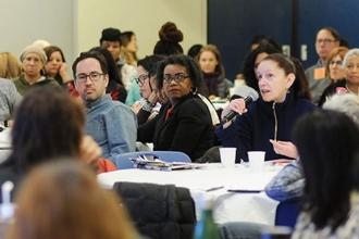 Myrta DaSilva (seated right, holding microphone), a social worker at PS 369 in B