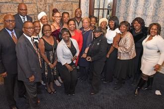 Joining a group shot of District 75 members are UFT Director of Staff LeRoy Barr