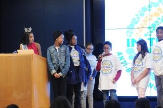 Kids on stage while one takes the mic