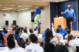 Police department representative on stage talking to kids